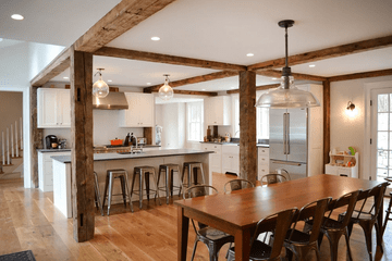 Original photo: a farmhouse kitchen with reclaimed wood beams and a long dining table